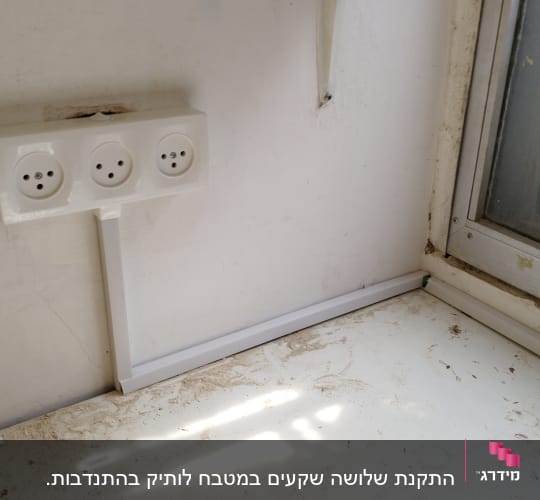 שקע חשמל תלת-כיווני על קיר לבן